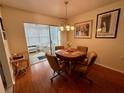 Cozy dining area with wood floors and a sunroom, perfect for enjoying meals and entertaining guests at 8704 Winding Wood Dr, Port Richey, FL 34668