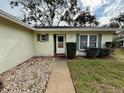 House entrance with walkway, landscaping, and light-colored exterior at 8704 Winding Wood Dr, Port Richey, FL 34668