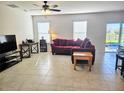 Inviting living room with comfortable seating, tile flooring, and natural light streaming through the windows at 10147 Cross Timber Ter, Land O Lakes, FL 34638