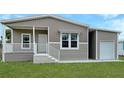 Front view of a tan home with attached carport and white accents at 14287 Rialto Ave, Brooksville, FL 34613