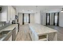 Modern kitchen with white cabinets, an island with granite countertops, and stainless steel appliances at 14287 Rialto Ave, Brooksville, FL 34613