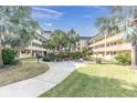 Ground level courtyard view of Port Bellaire condos, showing landscaping and walkway at 155 Bluff View Dr # 103, Belleair Bluffs, FL 33770
