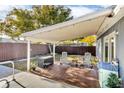 Covered wooden deck in backyard with seating, overlooking a fenced yard at 15950 Adobe Dr, Hudson, FL 34667