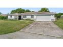 Single-story home with a white exterior, attached garage, and large front lawn at 2118 Huntington Ave, Sarasota, FL 34232