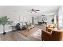 Open concept living and dining area with wood-look flooring, ceiling fans, and stylish furnishings at 2118 Huntington Ave, Sarasota, FL 34232