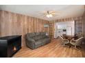 Cozy living area with fireplace, wood paneling, and open view to kitchen at 3844 Kim Dr, Wesley Chapel, FL 33543