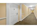 Well-lit hallway leading to individual condo units at 4516 Seagull Dr # 805, New Port Richey, FL 34652