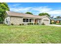Ranch style home with a spacious lawn and mature trees at 6288 Airmont Dr, Spring Hill, FL 34606