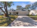 Attractive home with a patterned driveway, landscaping, and covered entryway at 6409 Wedgewood Dr, Spring Hill, FL 34606