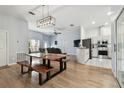 Open-concept dining area with a unique live-edge table and modern light fixture at 7717 Foxbear Ct, New Port Richey, FL 34655