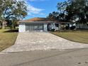 Ranch-style home with paved driveway and mature landscaping at 11556 Linden Dr, Spring Hill, FL 34608
