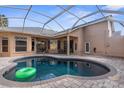 Relaxing kidney-shaped pool with a patio and covered lanai at 14101 Andrew Scott Rd, Spring Hill, FL 34609