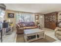 Living room with brown couch, coffee table, and wooden cabinet at 3049 Moog Rd, Holiday, FL 34691