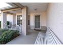 Covered entryway with a white bench and wrought-iron gate at 4635 Bellemede Blvd, New Port Richey, FL 34655