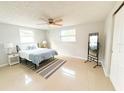 Main bedroom featuring a ceiling fan, ample natural light, and a full-length mirror at 7534 Birchwood Dr, Port Richey, FL 34668