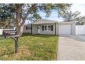 Front view of renovated home with landscaped yard at 9240 Whitman Ln, Port Richey, FL 34668