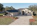 Beautiful home with attached garage, long driveway, and manicured landscaping at 9376 Bearwalk Path, Weeki Wachee, FL 34613
