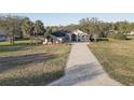Beautiful tan home featuring an extra long paved driveway with a big yard at 9376 Bearwalk Path, Weeki Wachee, FL 34613