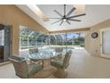 Screened-in patio with a large ceiling fan and dining table overlooks the sparkling pool at 18242 Autumn Lake Blvd, Hudson, FL 34667