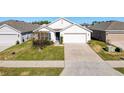 Charming single-story home with a well-manicured lawn and a two-car garage on a sunny day at 3337 Autumn Amber Dr, Spring Hill, FL 34609