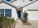 Front entrance with blue door, landscaping, and walkway at 3337 Autumn Amber Dr, Spring Hill, FL 34609