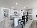 Modern kitchen with stainless steel appliances, granite countertops, and a large island at 3337 Autumn Amber Dr, Spring Hill, FL 34609