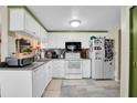 Well-lit kitchen offering white appliances, ample storage, mosaic tile backsplash, and modern flooring at 3337 Darlington Rd, Holiday, FL 34691