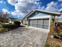 Front view of the house showcasing a gray garage door and brick driveway at 6381 Plantation Rd, Spring Hill, FL 34606