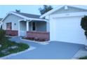 White garage door and walkway leading to the entrance of the house at 3518 Moog Rd, Holiday, FL 34691