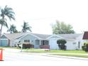 Ranch-style home with attached garage and landscaped lawn at 3518 Moog Rd, Holiday, FL 34691