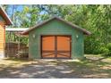 Green paneled garage featuring custom carriage doors at 6051 Valley Spring Dr, Brooksville, FL 34601