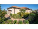 Well-maintained single-Gathering home with tile roof, lush landscaping, and brick walkway to the front at 3312 Francoa Dr, Odessa, FL 33556