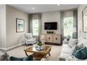 Cozy living room featuring stylish furniture, decor, large windows, and a modern television at 10008 Zennia Ln, Parrish, FL 34219