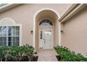 Close-up of the home's inviting entryway, featuring a decorative door and well-maintained landscaping at 7830 Becket St, New Port Richey, FL 34653