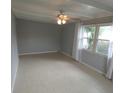Well lit living room with beamed ceilings, ceiling fan and multiple windows at 4011 W Mango Ave, Tampa, FL 33616