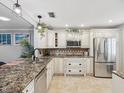Bright kitchen featuring stainless steel appliances, granite countertops, and custom white cabinetry at 3259 Hilary Cir # 1C, Palm Harbor, FL 34684