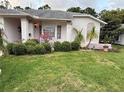 Charming single-story home showcasing a well-manicured lawn and mature plantings at 8111 Merrimac Dr, Port Richey, FL 34668