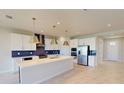 Modern kitchen with a spacious island, stainless steel appliances, and stylish blue backsplash at 10126 Zennia Ln, Parrish, FL 34219