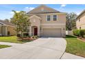 A home with a two-car garage, red front door, and landscaping at 12307 Duckett Ct, Spring Hill, FL 34610