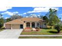 Inviting exterior of a one-story home with a manicured lawn and attached two-car garage at 14215 Presteign Ln, Spring Hill, FL 34609