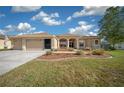 Charming one-story home featuring a well-manicured lawn and a driveway leading to a two-car garage at 14215 Presteign Ln, Spring Hill, FL 34609