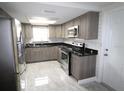Modern kitchen featuring stainless steel appliances, gray cabinets, and stylish granite countertops at 5641 Quist Dr, Port Richey, FL 34668