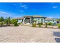 Stunning light blue home features a paver driveway and a beautifully landscaped front yard at 10030 Orchard Way, Spring Hill, FL 34608