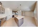 Modern kitchen boasts stainless appliances, granite countertops, and a large center island with pendant lighting at 10127 Zennia Ln, Parrish, FL 34219