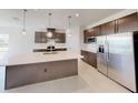 Contemporary kitchen featuring stainless steel refrigerator, sleek cabinetry, and a spacious island with sink at 10127 Zennia Ln, Parrish, FL 34219
