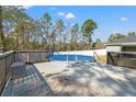 Pool deck showcasing the above ground pool, with a safety cover and a surrounding privacy screen at 13094 Tailorbird Ave, Brooksville, FL 34614