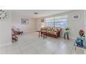 Bright and airy living room with tile flooring, wicker furniture, and a comfortable rocking chair at 13705 Allyn Dr, Hudson, FL 34667