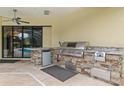 Outdoor kitchen boasts a built-in grill and stone accents, perfect for alfresco dining and entertaining at 20200 Lace Cascade Rd, Land O Lakes, FL 34637
