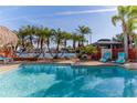 Relaxing pool with tropical landscaping, a tiki hut, and a beautiful waterfront view at 3308 Oleander Dr, Hernando Beach, FL 34607