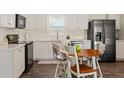 Modern kitchen featuring white cabinets, stainless steel appliances, and a wood table with chairs at 3323 Parlow Ave, Spring Hill, FL 34606
